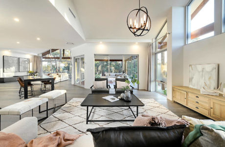 Modern open-plan living room with high ceiling and stylish decor.