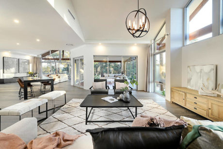 Modern open-plan living room with high ceiling and stylish decor.