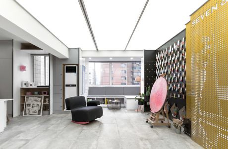 Modern office lobby with armchairs, a wine rack wall, and skyl