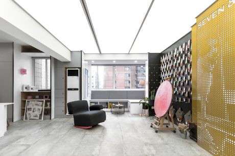 Modern office lobby with armchairs, a wine rack wall, and skyl