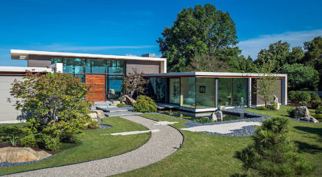 Modern house with large glass windows and landscaped garden.