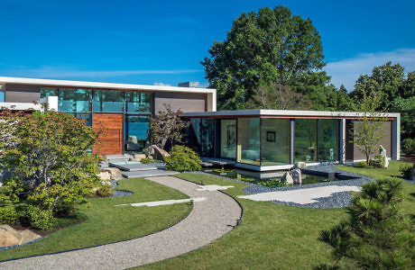 Modern house with large glass windows and landscaped garden.