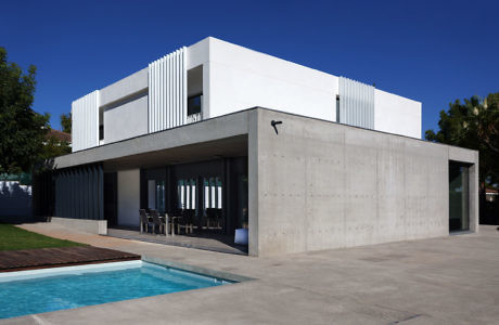 Contemporary cubiform house with pool and concrete accents.