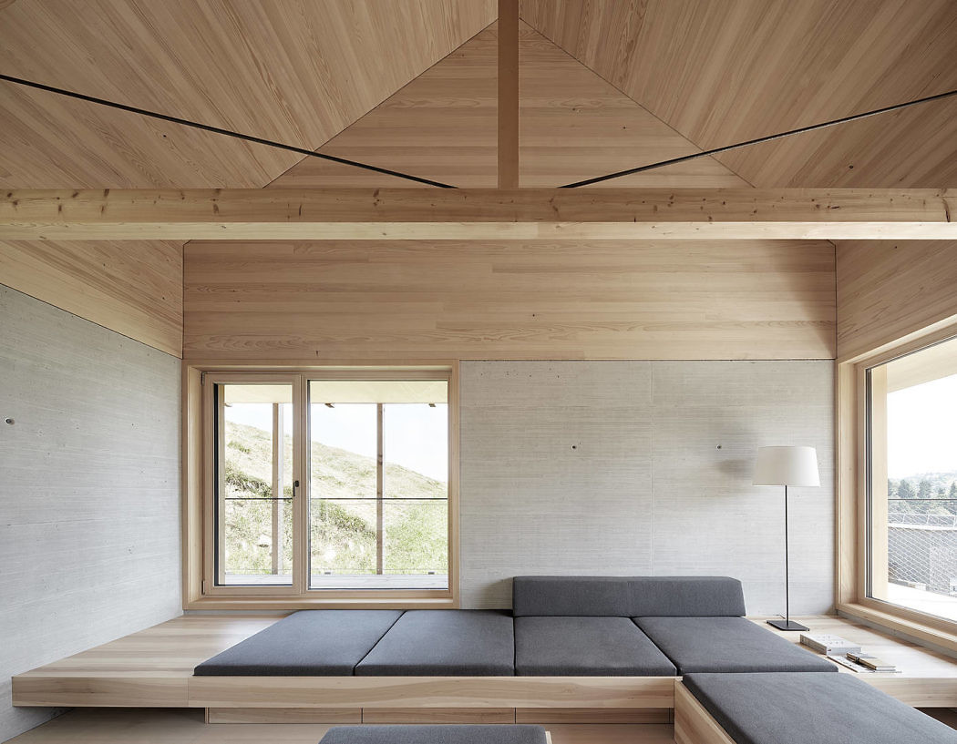 Minimalist interior with wooden ceiling, walls, and built-in seating by a window