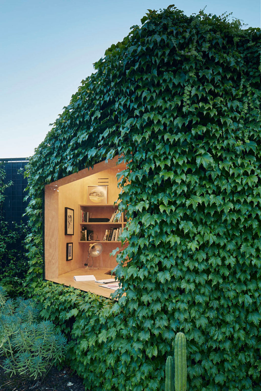 Verdant ivy-clad exterior with a cozy, wooden interior office no