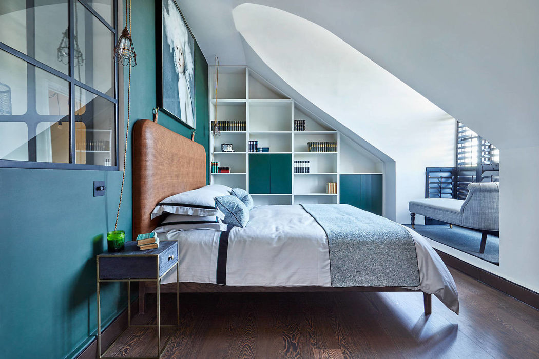 Sleek bedroom with curved ceiling, built-in shelves, and teal walls.