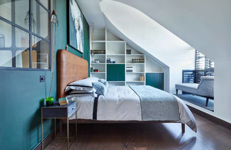 Sleek bedroom with curved ceiling, built-in shelves, and teal walls.