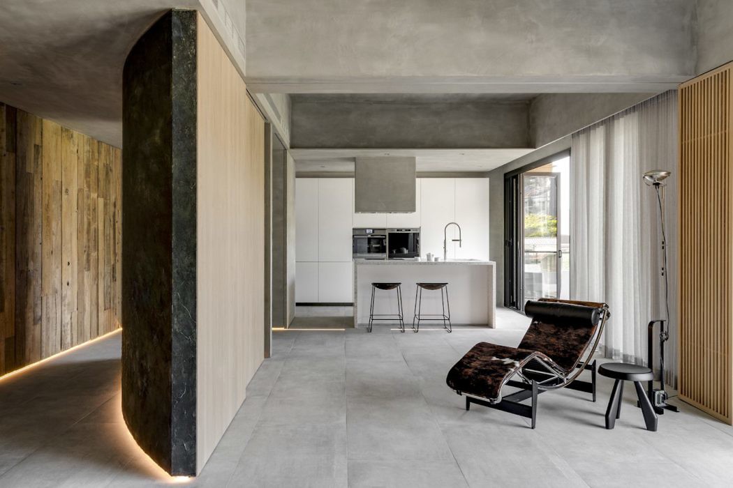 Modern minimalist interior with a concrete finish, wooden accents, and sleek furniture.