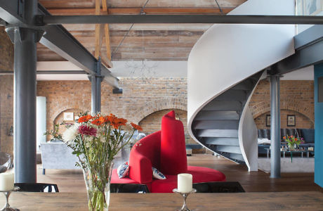 Industrial loft with a spiral staircase and exposed beams.