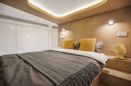 Contemporary bedroom with ambient lighting and wood accents.