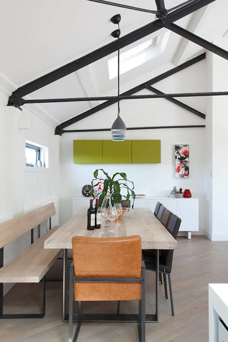 Contemporary dining room with exposed beams and minimalist decor.