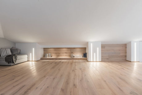 Modern minimalist interior with wooden floors and indirect lighting.