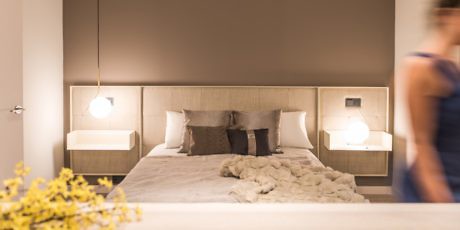 Contemporary bedroom with neutral tones and pendant lighting.
