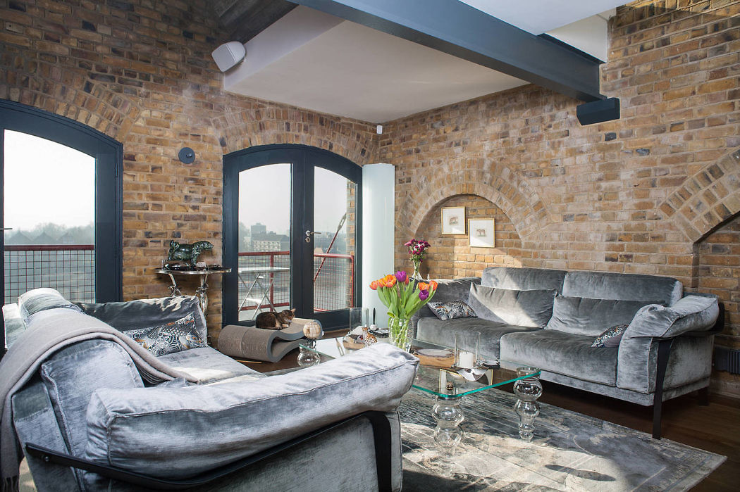 Chic loft living room with exposed brick walls and plush sofas.