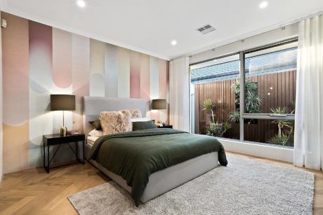 Modern bedroom with colorful wall design, large bed, and window view.