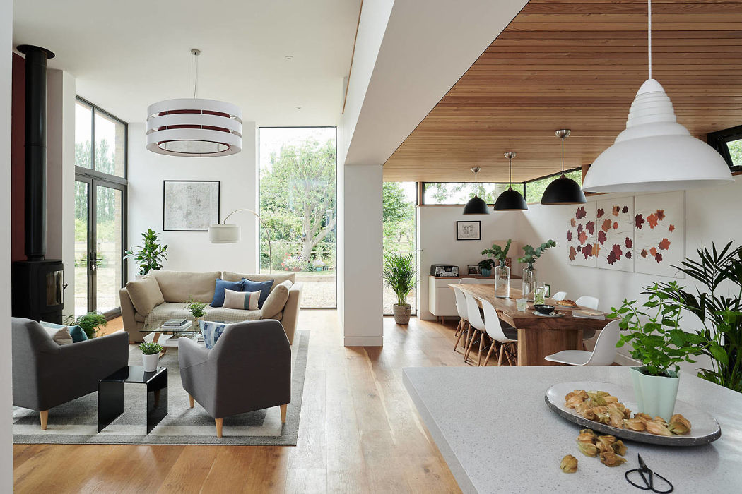 Modern open-plan living room and dining area with stylish furnishings and large windows.