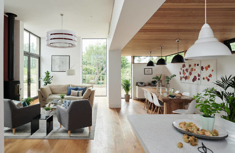 Modern open-plan living room and dining area with stylish furnishings and large windows.