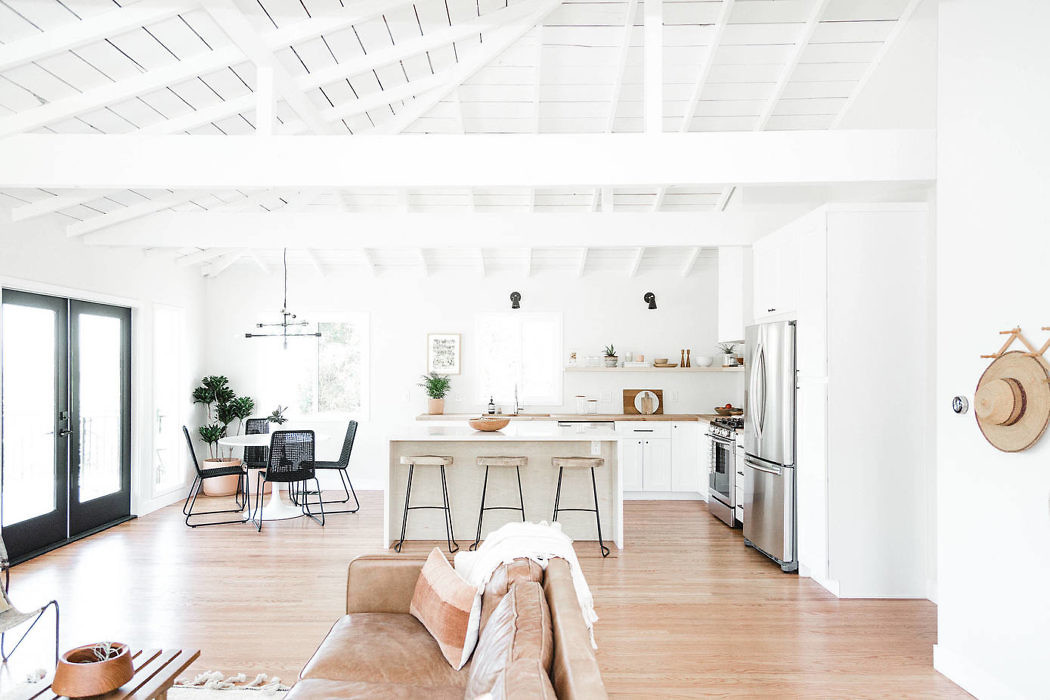 Bright, airy open-plan kitchen with white beams and hardwood floors.