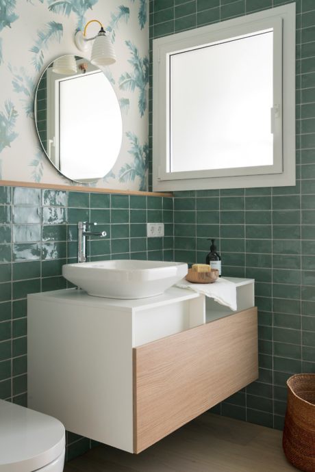 Contemporary bathroom with teal tiles and wooden vanity.