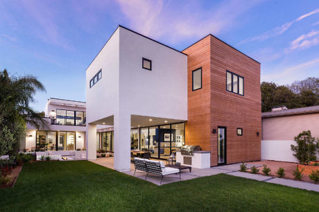 Contemporary house with white and wood exterior, large windows, and open patio.