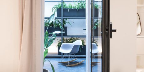 Contemporary room with white Eames chair and indoor plants.