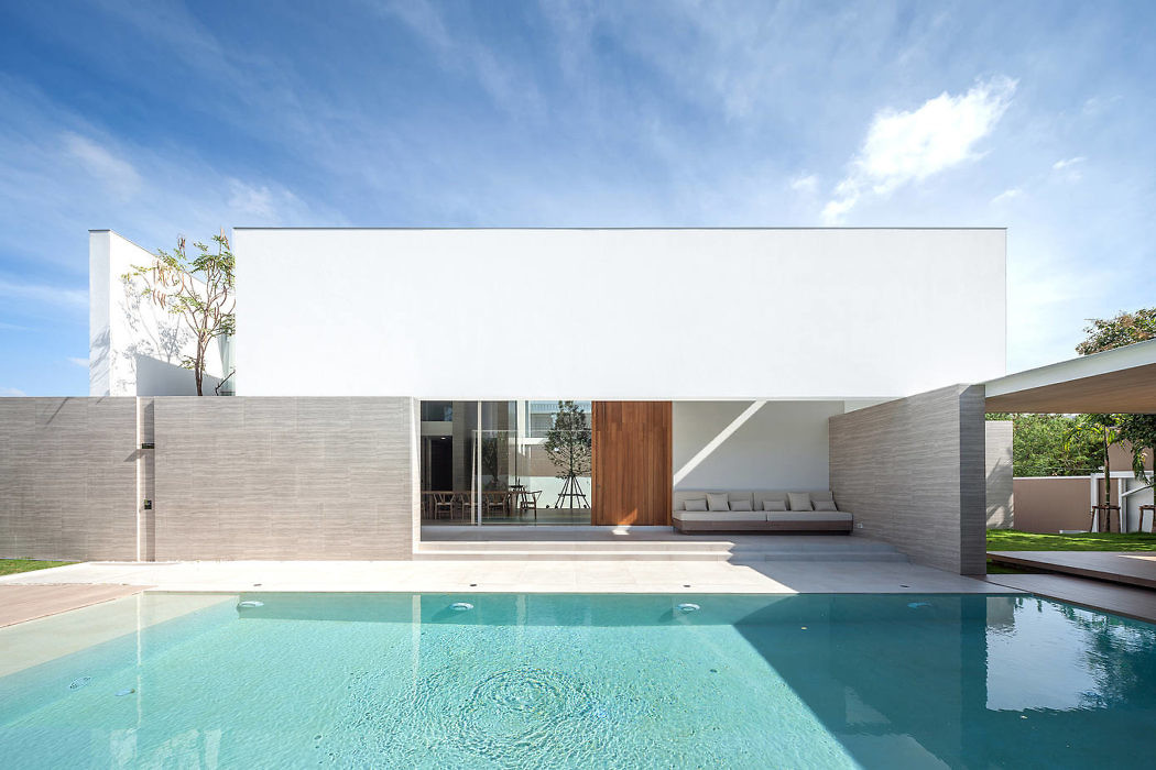 Modern house with white facade, large windows, and pool.