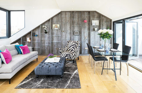 Modern living room with dining area, stylish furniture, and wooden paneling.