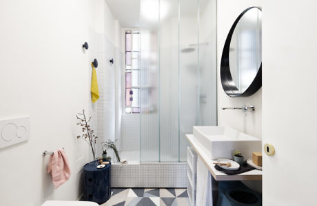 Contemporary bathroom with geometric tiles and glass shower.