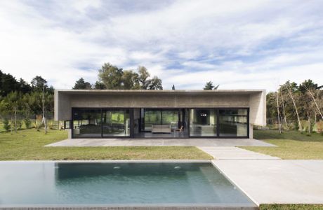 Minimalist house with large windows and a pool.