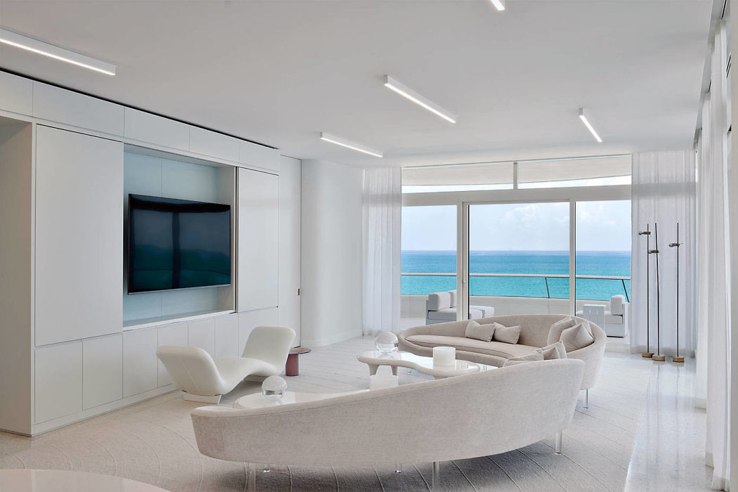 Contemporary living room with ocean view and sleek white decor.