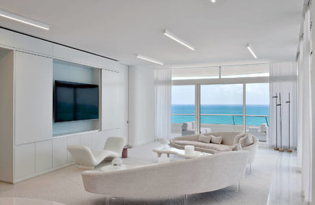 Contemporary living room with ocean view and sleek white decor.