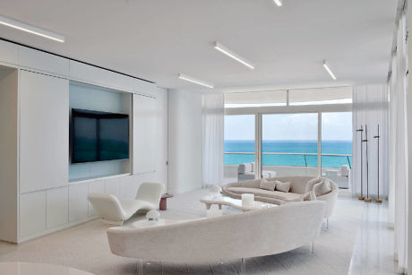 Contemporary living room with ocean view and sleek white decor.