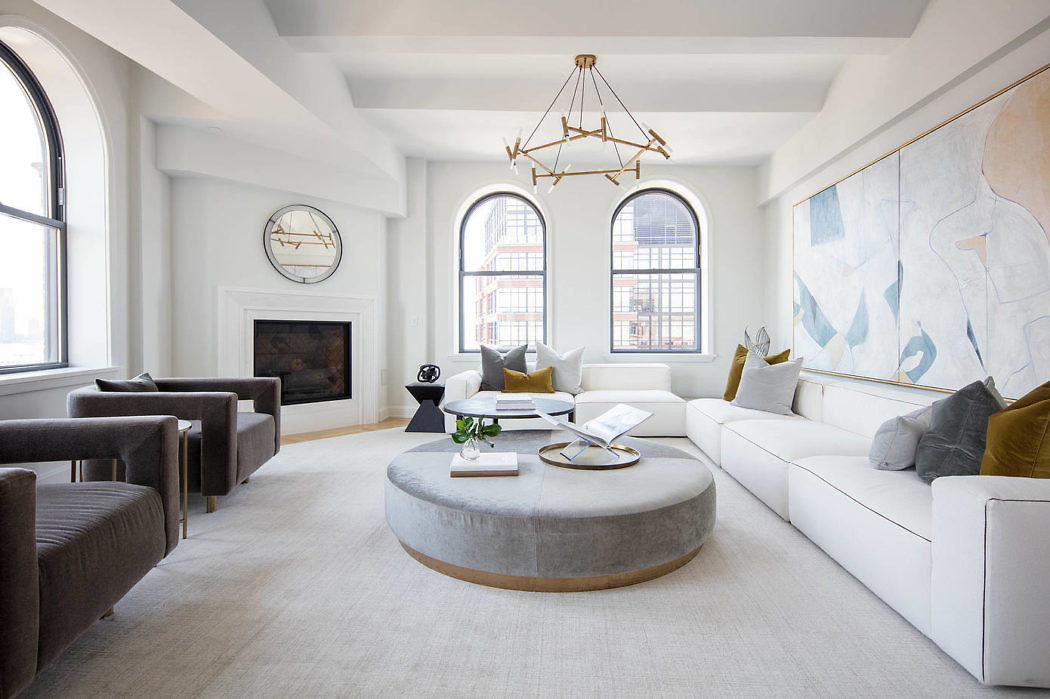 Elegant living space with large windows, minimalist decor, and a striking art piece