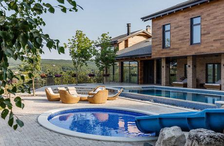 Contemporary home with pool and wicker loungers.