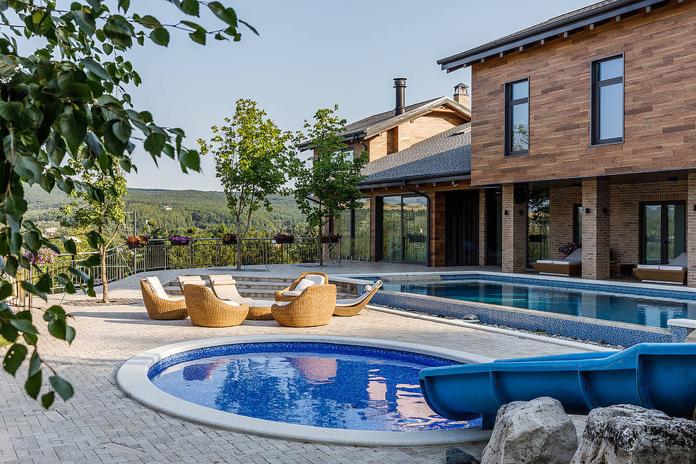 Contemporary home with pool and wicker loungers.