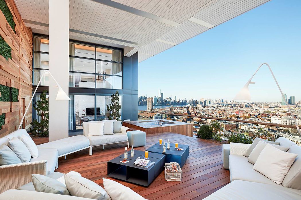 Chic rooftop terrace with sleek furniture and a city skyline view.