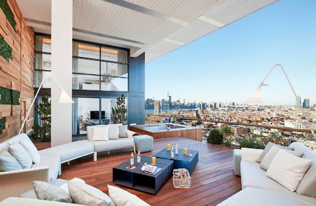 Chic rooftop terrace with sleek furniture and a city skyline view.