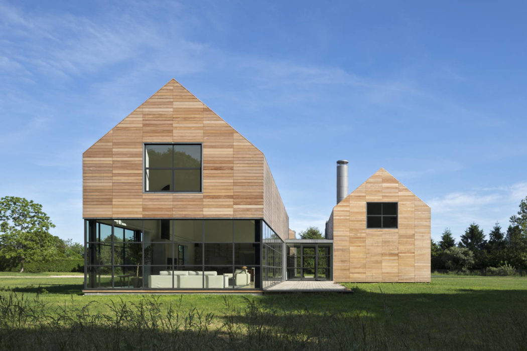 Modern wooden house with geometric design and large windows.