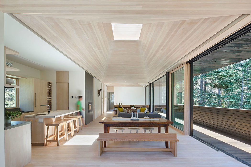 Sleek wooden interior with natural light and floor-to-ceiling windows.