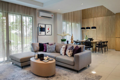 Modern living room with sectional sofa, wood accents, and dining area in background.