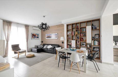 Contemporary living space with sleek furnishings and a bookshelf.