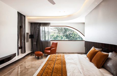 Modern bedroom with sleek design, large bed, and floor-to-ceiling windows.