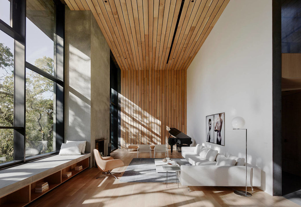 Modern living room with large windows, wooden ceiling, and minimalist furniture.