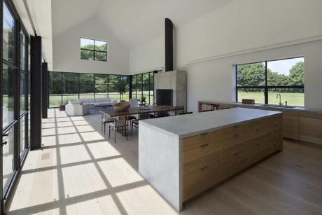 Modern kitchen with large island, floor-to-ceiling windows, and a fireplace.