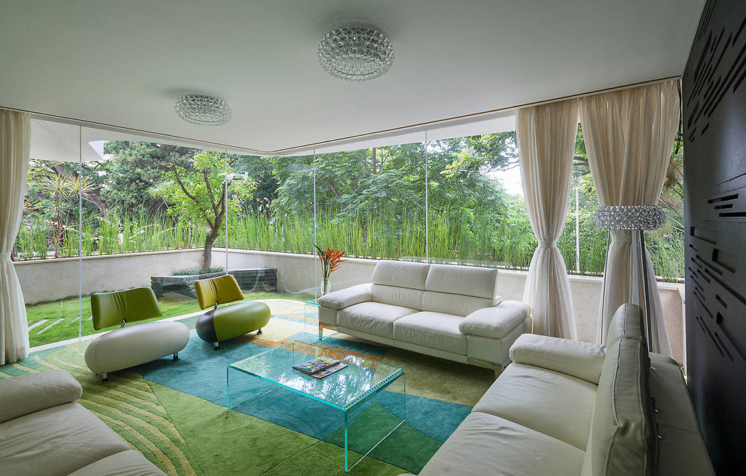 Modern living room with large windows overlooking greenery.