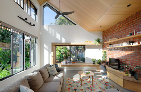 Modern living room with brick wall, large windows, and geometric-patterned floor.