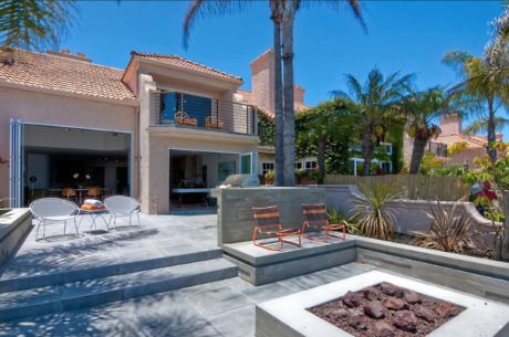 Luxury house exterior with patio and fire pit.