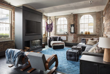 Chic living room with exposed brick walls, plush seating, and a large fireplace