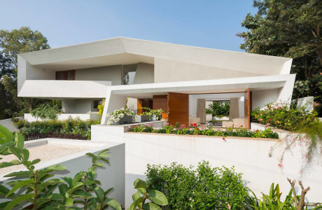 Contemporary house with geometric design and lush garden.