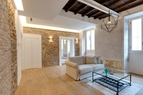 Contemporary room with exposed brick and beams, minimalist furniture.